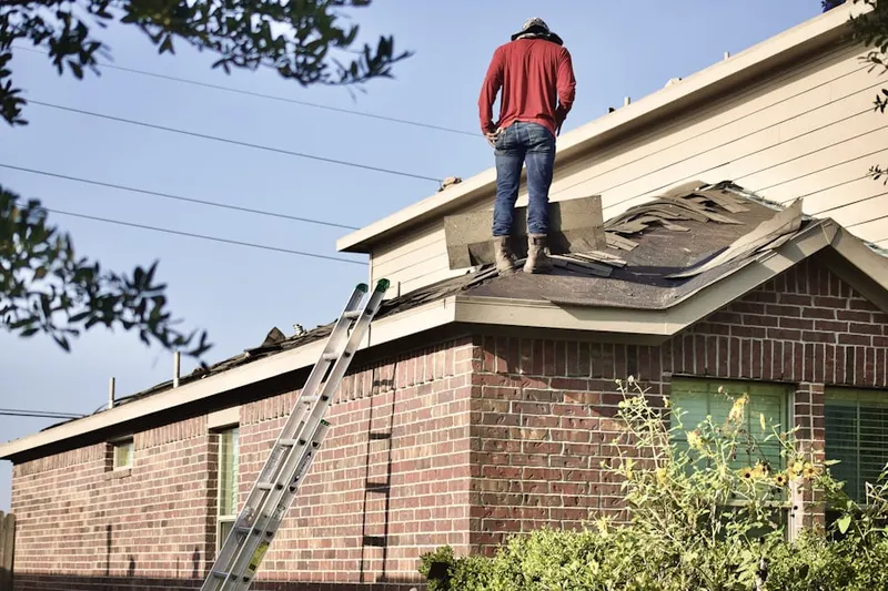 Professional roofer working on a residential roof in Studebaker